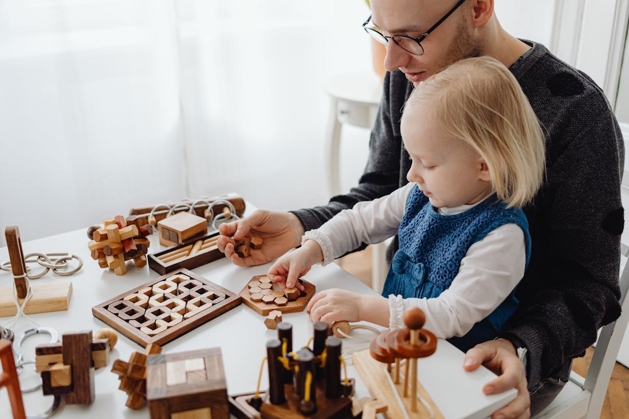 A father and child enjoying wooden puzzles together at a table indoors, fostering creativity and learning.